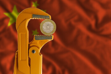 100 Kazakhstani tenge held in an orange plumber wrench on the background of the flag of China....