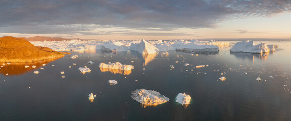 Climate change and global warming. Icebergs from a melting glacier in Greenland. The icy landscape...