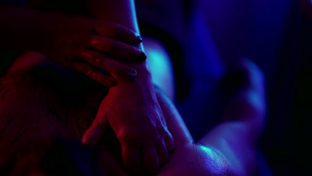 medical massage in spa salon, woman is stroking male chest and shoulder, close up view of female hands