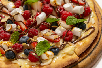 sweet pizza with berries and marshmallow on white background