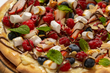sweet pizza with berries and marshmallow on white background