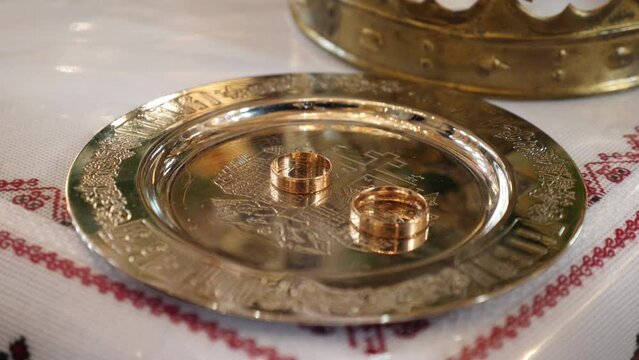 Golden wedding rings on a tray for a church wedding. Objects of church worship and national rites.