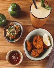 Chicken Karaage with salad, sauce and milkshake on wooden table