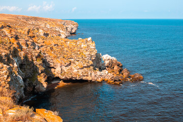 High rocky mountains and blue sea on a sunny day. Seascape. Travel and tourism