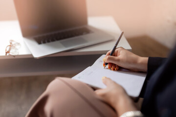 Closeup Psychologist taking notes in notebook during online psychological consultation, developmental coaching session