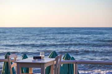Obraz premium Empty reserved table at a greek taverna and the sea in background