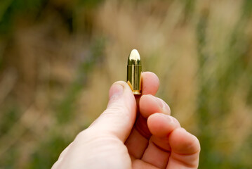 the hand holds a live cartridge. cartridge close-up. cartridge in hand