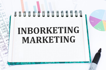 Inborketing marketing text on notepad on the background of reports and charts