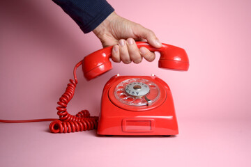 Make that call today - classic rotary dial telephone being picked up by a hand - obrazy, fototapety, plakaty