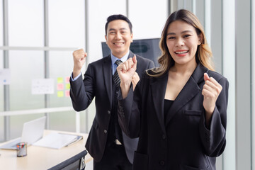Portrait of asian business group people in suit standing in modern office smiling raising hand celebrating success teamwork