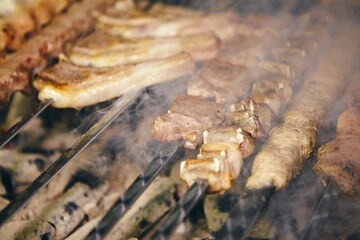 Shish kebab on skewers from different types of meat is fried on the grill