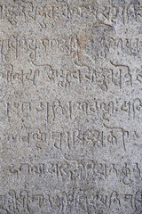 Inscriptions of tamil text on the walls of historical ancient temple in Tamilnadu. Ancient tamil inscriptions carved in the exterior temple walls. Stone wall texture.