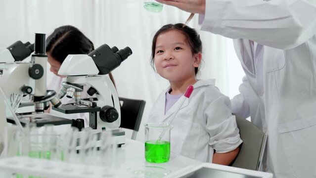 Asian kid learning with scientist in the laboratory. Physical examination and science education class.