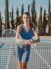 Mujer joven y guapa en una pista de tenis con una raqueta de tenis.