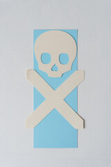 paper skull and X crossbones on blue paper 