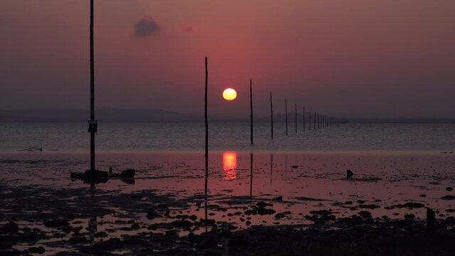 Sunset over sand on Lindisfarne holy island relaxing and meditation in nature. Northumberland seaside with sun going down over water in evening UK 4K