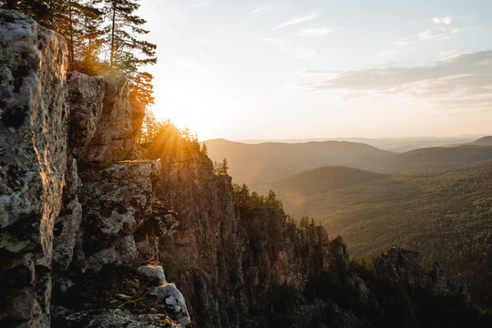A beautiful landscape in the mountains at sunset, the evening sun glare orange, the mountain range is rocky, the southern Urals mount Karatash.
