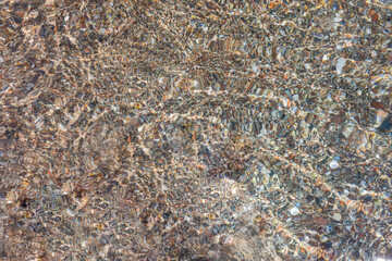 Close up view of texture of the seabed underwater with reflections from sun.