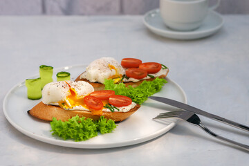Poached egg toast with tomato and cream cheese and bread on a plate. Healthy food concept.