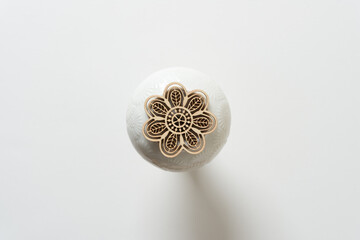 flower shaped wooden ornament on a ceramic object