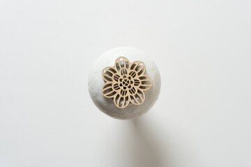 floral or spiral wooden ornament on a circular ceramic object