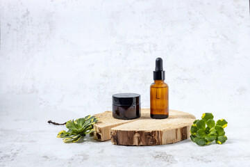 Naklejka premium containers for cosmetics on the podium made of cut wood and green flower leaves