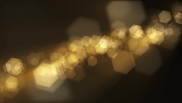 Defocused golden bokeh lights background. This elegant motion background animation with hexagonal lens blur bokeh particles is full HD and a seamless loop.