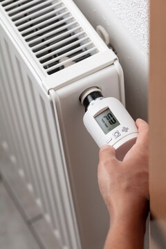 Stockfoto med beskrivningen Woman's hand adjusting radiator temperature. |  Adobe Stock