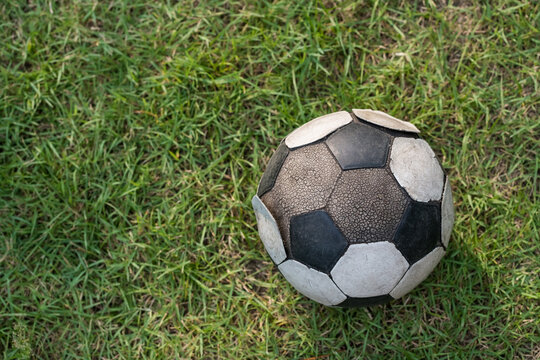 Ruin soccer ball or football on green grass by top view