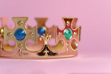 Cropped gold crown with jewels isolated on pink