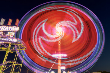 Circular colored lights of fairground attraction at night