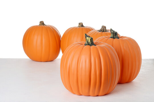 row of fake plastic pumpkins on a white background
