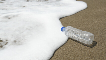 A used plastic bottle is lying on the beach. Environmental problems.