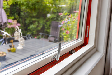 View from the window to the garden in the summer on a sunny day. Ajar window.