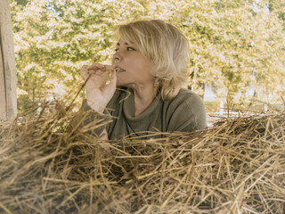 Blond girl with green eyes in nature. Happy middle aged woman on a farm