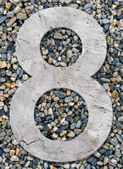 Number 8 with concrete texture, on stones background