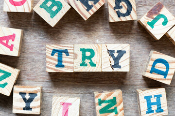 Alphabet letter block in word try and another letter on wood background