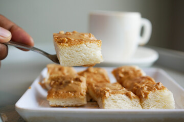 peanut butter spread on bread and cup of tea on table 