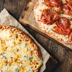 Two Roman-style pizzas with cheese and jamon serrano. Roman square pizza or Pinsa on thick dough,...