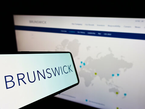 Stuttgart, Germany - 12-12-2021: Mobile phone with logo of American boating company Brunswick Corporation on screen in front of website. Focus on center-left of phone display.