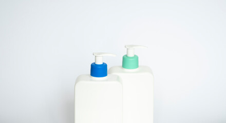 Two white plastic bottles with black dispenser, isolated on white background