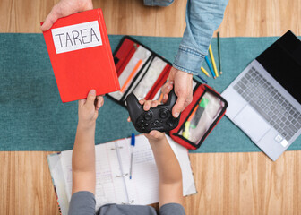 Rewarded with video games for finishing his tarea (Spanish for homework). Top view