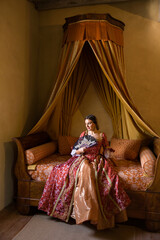 Renaissance lady on antique bed © Anneke