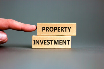 Property investment symbol. Concept words Property investment on wooden blocks on a beautiful grey table grey background. Businessman hand. Business Property investment concept. Copy space.