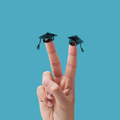 V sign and graduation hat on fingers