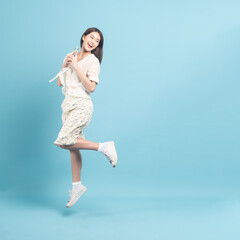 Beautiful young asian woman in white dress with flower pattern using smartphone and jump  isolated...