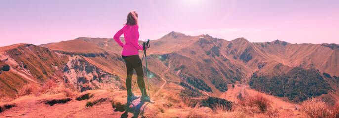 hiker woman on a mountain peak looking at panoramic view of Puy de Sancy- France, massif central