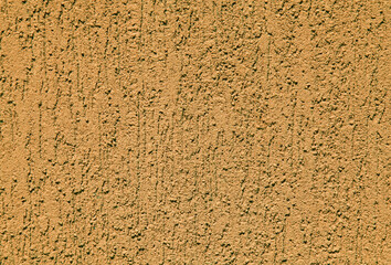 View of yellow wall. Terracota texture, background. Plastered building wall. Rough, textured and decorated surface with vertical embossed pattern. Apricot and amber wall surface. Modern coating