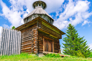 Wooden watchtower of an ancient fortress built in the 17th century. An ancient watchtower to protect against attacks against the background of the forest and the blue sky. Ancient wooden architecture.