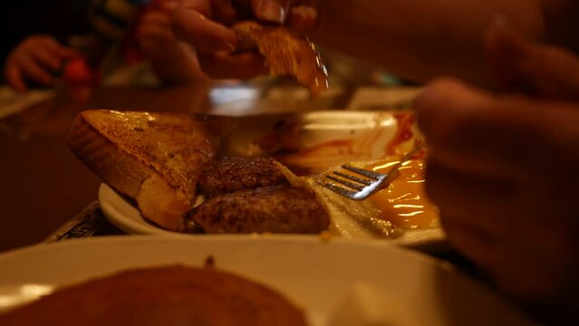 Woman dipping toast in egg yolk in breakfast diner